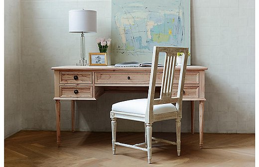 The five-drawer Colette Desk has traditional fluting and brass pulls, but the mindi wood gives it an of-the-moment appeal. 
